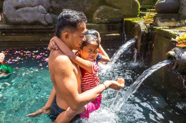 BALI, INDONEZYA - 28 Şubat 2020: Bali halkı Endonezya 'nın Bali kentindeki Pura Tirta Empul Tapınağı' ndaki kutsal havuzda dua ediyor