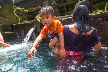 BALI, INDONEZYA - 28 Şubat 2020: Bali halkı Endonezya 'nın Bali kentindeki Pura Tirta Empul Tapınağı' ndaki kutsal havuzda dua ediyor