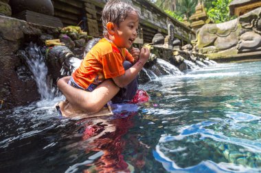 BALI, INDONEZYA - 28 Şubat 2020: Bali halkı Endonezya 'nın Bali kentindeki Pura Tirta Empul Tapınağı' ndaki kutsal havuzda dua ediyor