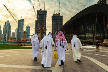 DUBAI, BAE - 5 Nisan 2020: Dubai şehir merkezinde, Birleşik Arap Emirlikleri 'nde geleneksel beyaz elbiseler giyen Arap erkekler