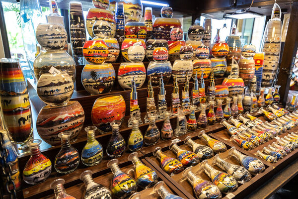 DUBAI, UNITED ARAB EMIRATES - 31 ЯНВАРЯ 2020: Ремесленник делает пейзажи сцены в бутылке, используя цветной песок в Madinat Jumeirah в Дубае, Объединенные Арабские Эмираты