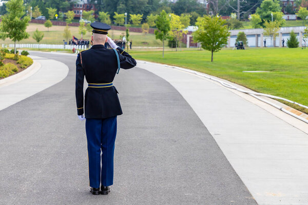 WASHINGTON DC, USA - MARCH 29, 2020: US soldier giving salute at Military burial ceremony in Arlington national cemetery in Washington DC, USA