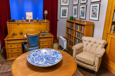 NORTHUMBERLAND, İngiltere - 13 Ağustos 2025: Kitap rafları, ahşap masa ve Northumberland, İngiltere 'deki Cragside House içinde Doğu Asya sanat eserleri bulunan tarihi Japon Odası