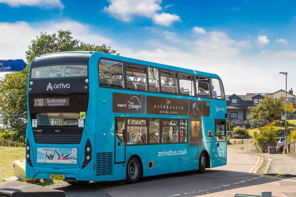 NORTHUMBERLAND, İngiltere - 15 Ağustos 2025: Blue Arriva X18 çift katlı otobüs Northumberland, İngiltere 'deki Craster kıyı köyünden geçiyor