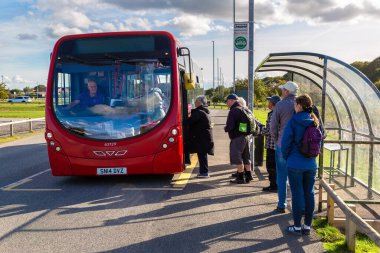 DONCASTER, İngiltere - 16 Eylül 2025: Güney Yorkshire, İngiltere 'de Doncaster yakınlarındaki Yorkshire Wildlife Park otobüs durağında kırmızı otobüs güzergahına binen yolcular
