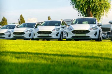 Satır stok araba galerisinde yepyeni beyaz otomobillerin. Satılık satılmamış arabalar.