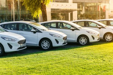 Satır stok araba galerisinde yepyeni beyaz otomobillerin. Satılık satılmamış arabalar.