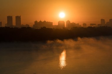 Dneper, Kiev, Ukrayna üzerinden kırmızı yükselen güneş ışınlarının bir horizont bir şehir bina siluet. Kentsel silueti kavramı