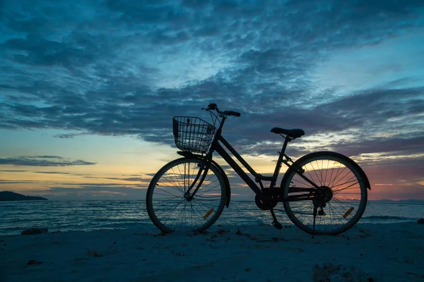 老式自行车剪影与篮子在海滩在晚上在日落背景 — 图库照片
