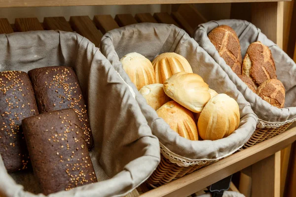 Ассортимент свежего хлеба в корзинах в пекарне — стоковое фото