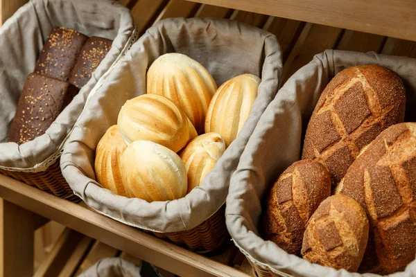 Sortimento de pão fresco em cestas na padaria — Fotografia de Stock