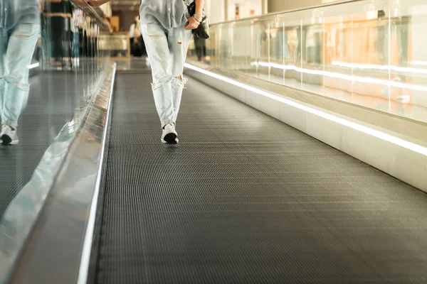 Frau bewegt sich auf Rolltreppe auf Kamera am Flughafen zu — Stockfoto