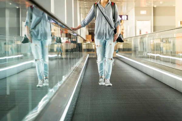 空港でカメラに向かってエスカレーターで移動している女性 — ストック写真