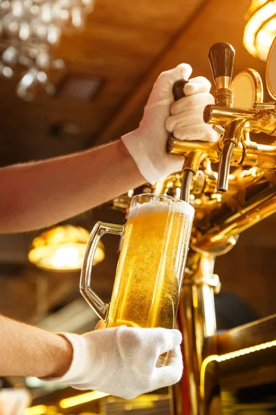 Barman handen gieten licht bier in een glas — Stockfoto