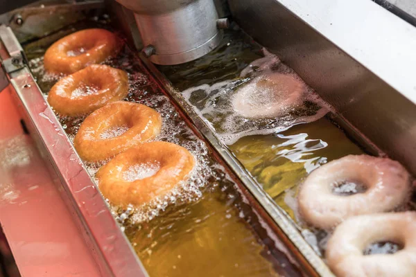 뜨거운 기름에 튀긴 도넛의 준비. — 스톡 사진