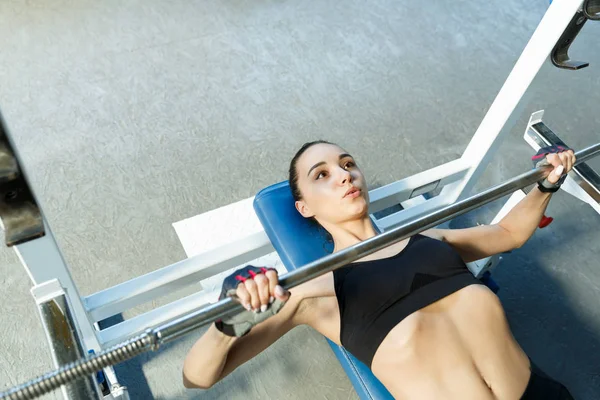 Bir spor salonunda Kadın perfoms bir eğitmen ben bir halter ile egzersizleri