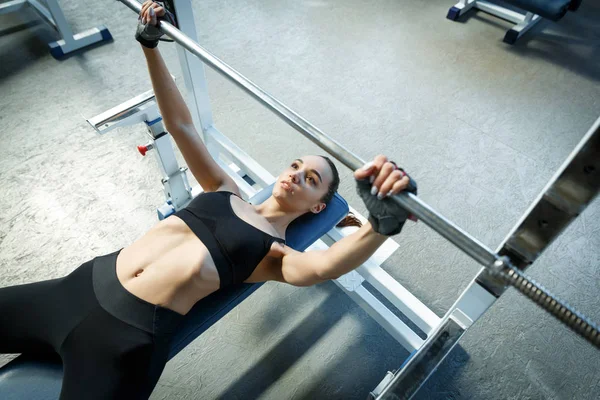 Bir spor salonunda Kadın perfoms bir eğitmen ben bir halter ile egzersizleri