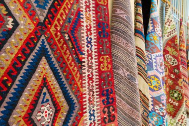 Eski şehir Kaleiçi'de bir sokakta duvara asılı farklı geleneksel Türk halıları, Antalya, Türkiye