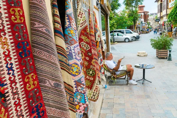 Vendedor negociando tapetes turcos tradicionais em uma rua em t velho — Fotografia de Stock