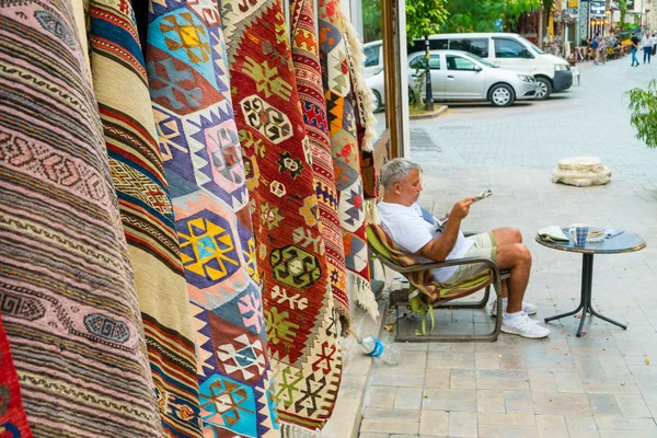 Vendedor negociando tapetes turcos tradicionais em uma rua em t velho — Fotografia de Stock