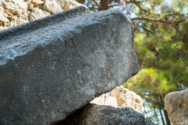 Texto grego esculpido em pedras antigas de Phaselis ruínas, g antient — Fotografia de Stock