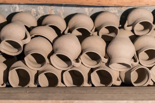 Fresh handmade molded clay jars drying on a shelf in a potter's — Stock Photo, Image