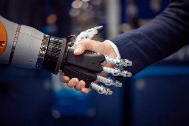 Android bir robotla el sıkışan bir iş adamının eli. Yapay zekayla insan etkileşimi kavramı.