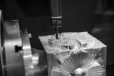 Metalworking CNC milling machine. Cutting metal modern processing technology. Small depth of field. Warning - authentic shooting in challenging conditions. A little bit grain and maybe blurred. clipart
