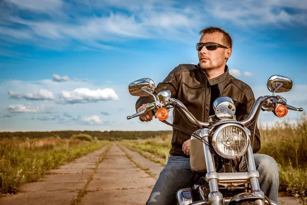 骑自行车的人男人穿着一件皮夹克和坐在他的摩托车上的太阳镜 — 图库照片