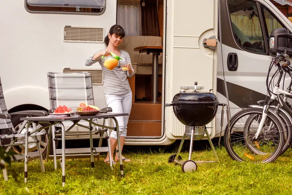 家族での休暇旅行の キャンピングカー キャラバン車休暇で旅行 屋外バーベキュー ピクニック 女性はオレンジ ジュースのガラスを注ぐ — ストック写真