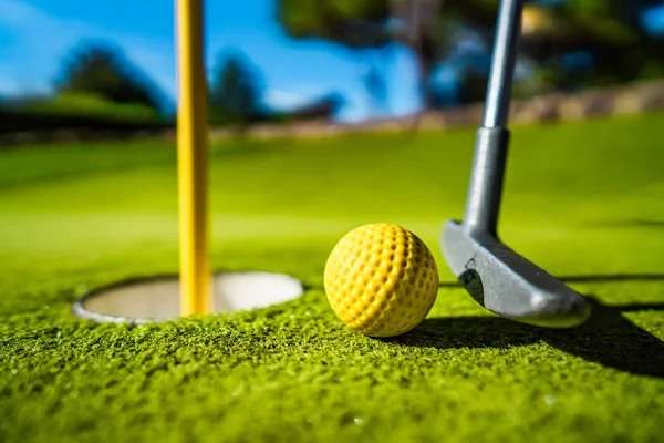 Mini Golf Žlutý Míč Pálkou Blízkosti Otvoru Při Západu Slunce — Stock fotografie