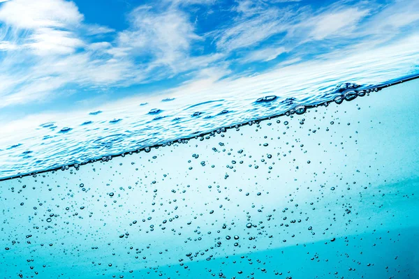 水の多くの空気の泡をクローズ アップ 青空を背景に泡波を抽象化 — ストック写真