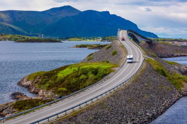 Karavan araba otoyolda seyahat eder. Atlantic Ocean Road veya Atlantik yol (Atlanterhavsveien) başlık (Norveç inşaat yüzyılın verilmiştir).