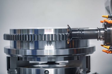 Metalworking CNC milling machine. Cutting metal modern processing technology. Small depth of field. Warning - authentic shooting in challenging conditions. A little bit grain and maybe blurred. clipart