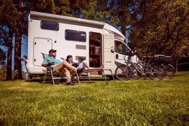Woman with a man resting near motorhomes in nature. Family vacation travel, holiday trip in motorhome RV, Caravan car Vacation. clipart