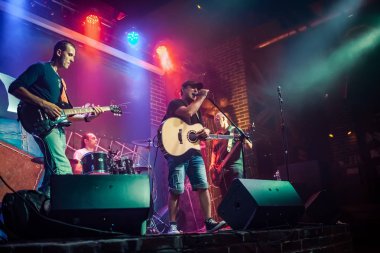 Grup sahne, rock müzik konseri bir gece kulübünde gerçekleştirir. Otantik ile zorlu ışık koşullarında yüksek ISO çekim. Biraz tahıl ve bulanık hareket efektleri.