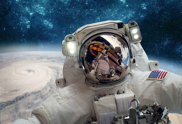 Astronaut in outer space against the backdrop of the planet earth. Typhoon over planet Earth. Elements of this image furnished by NASA.
