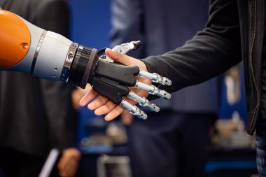 Android bir robotla el sıkışan bir iş adamının eli. Yapay zekayla insan etkileşimi kavramı.