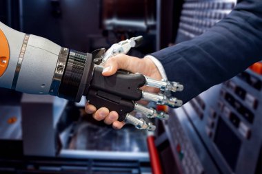 Android bir robotla el sıkışan bir iş adamının eli. Yapay zekayla insan etkileşimi kavramı.