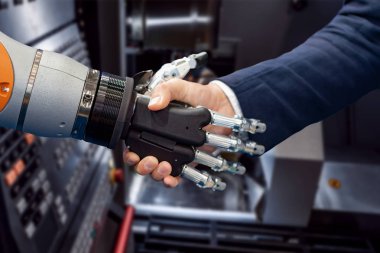 Android bir robotla el sıkışan bir iş adamının eli. Yapay zekayla insan etkileşimi kavramı.