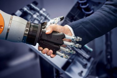 Android bir robotla el sıkışan bir iş adamının eli. Yapay zekayla insan etkileşimi kavramı.