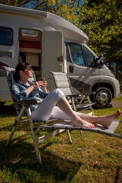 Mujer está de pie con una taza de café cerca de la caravana RV . —  Fotos de Stock