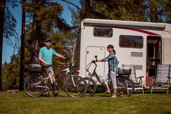 Mujer con un hombre en bicicleta eléctrica descansando en el camping . —  Fotos de Stock