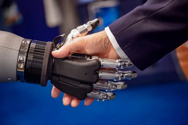 Hand of a businessman shaking hands with a Android robot. — Stock Photo, Image