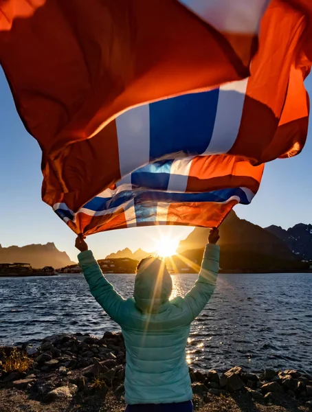 Frau schwenkt bei Sonnenuntergang die norwegische Flagge — Stockfoto