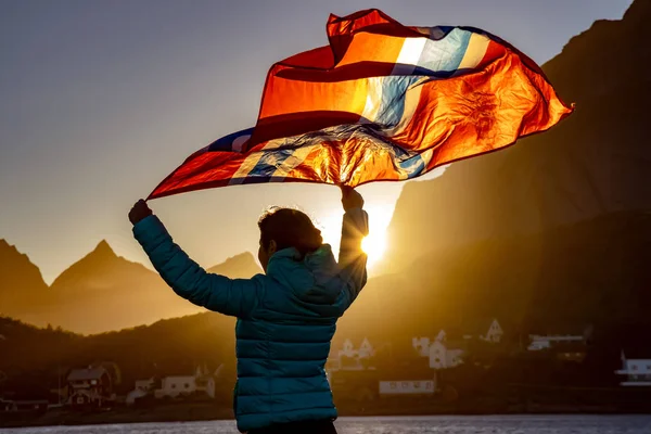 Frau schwenkt bei Sonnenuntergang die norwegische Flagge — Stockfoto