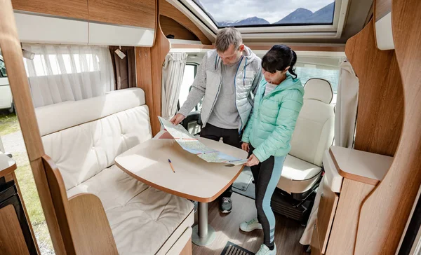 Couples in RV Camper looking at the local map for the trip. — Stock Photo, Image