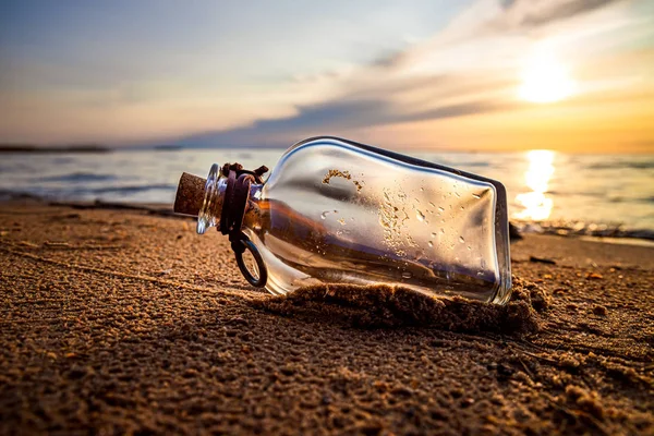 Meddelande i flaskan mot solnedgången — Stockfoto