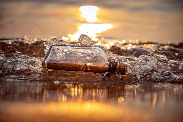 Message in the bottle against the Sun setting down — Stock Photo, Image