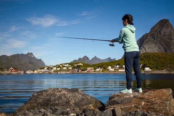 Mulher pesca na vara de pesca girando na Noruega . — Fotografia de Stock